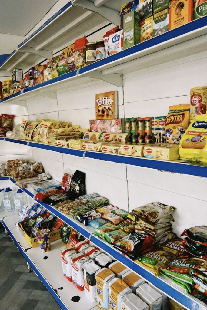 Colorful assortment of packaged grocery items displayed on shelves in a Kazakhstan store.